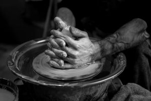 Jones, Alex. A clay stained hand of a potter engaging in a craft work of pottery or molding. Fotografía digital. Unsplash, 2024